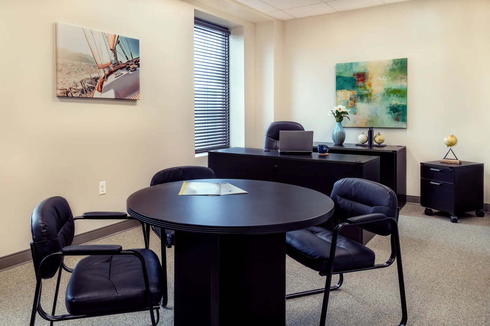 Corner office with a desk and meeting area.