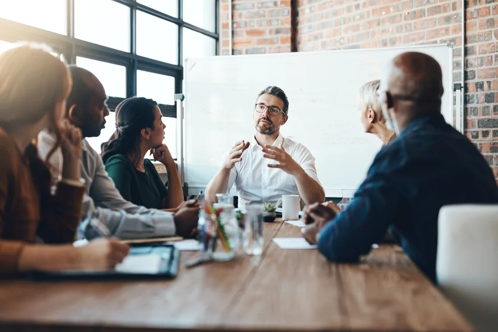 A business team meeting around a conference table in an Annapolis meeting room.