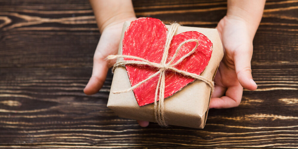 Children’s,Hands,Hold,Gift,Box,On,A,Wooden,Table-top.a,Concept