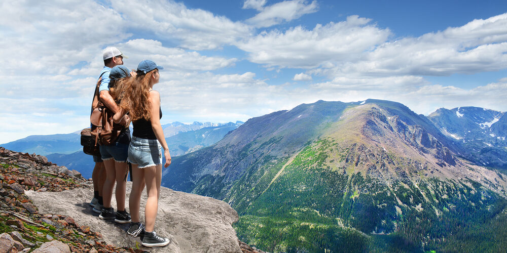 Father,With,Arms,Around,His,Family,Looking,At,Summer,Mountains
