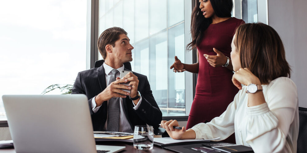 Business,Team,Of,Three,Planning,Work,In,Office,,With,Female A modern coworking space featuring sleek desks, professional meeting rooms, and attorneys collaborating in a bright, inviting environment.