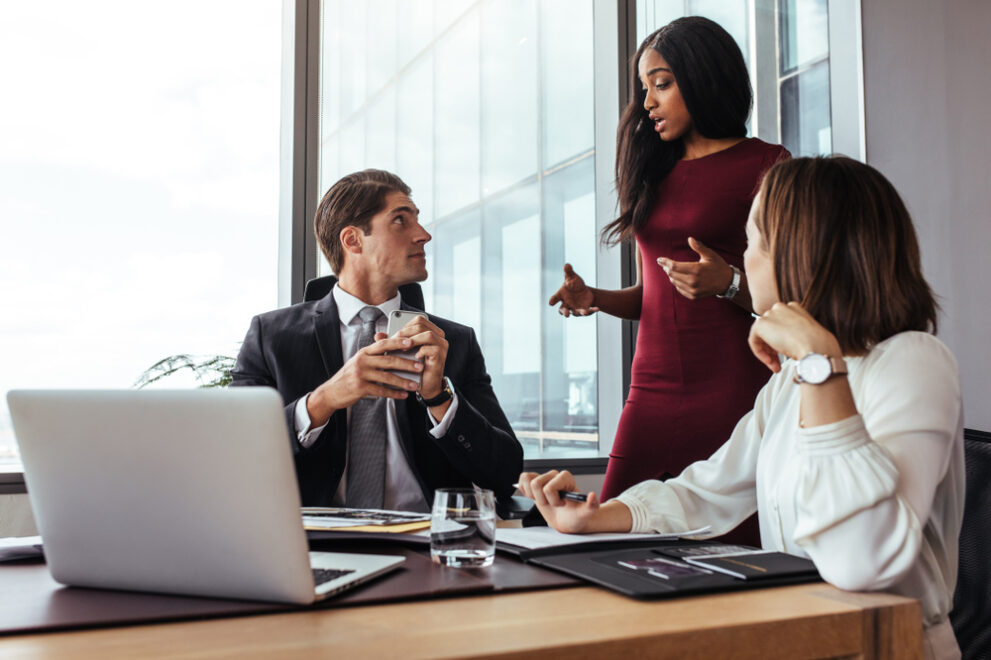 Business,Team,Of,Three,Planning,Work,In,Office,,With,Female A modern coworking space featuring sleek desks, professional meeting rooms, and attorneys collaborating in a bright, inviting environment.