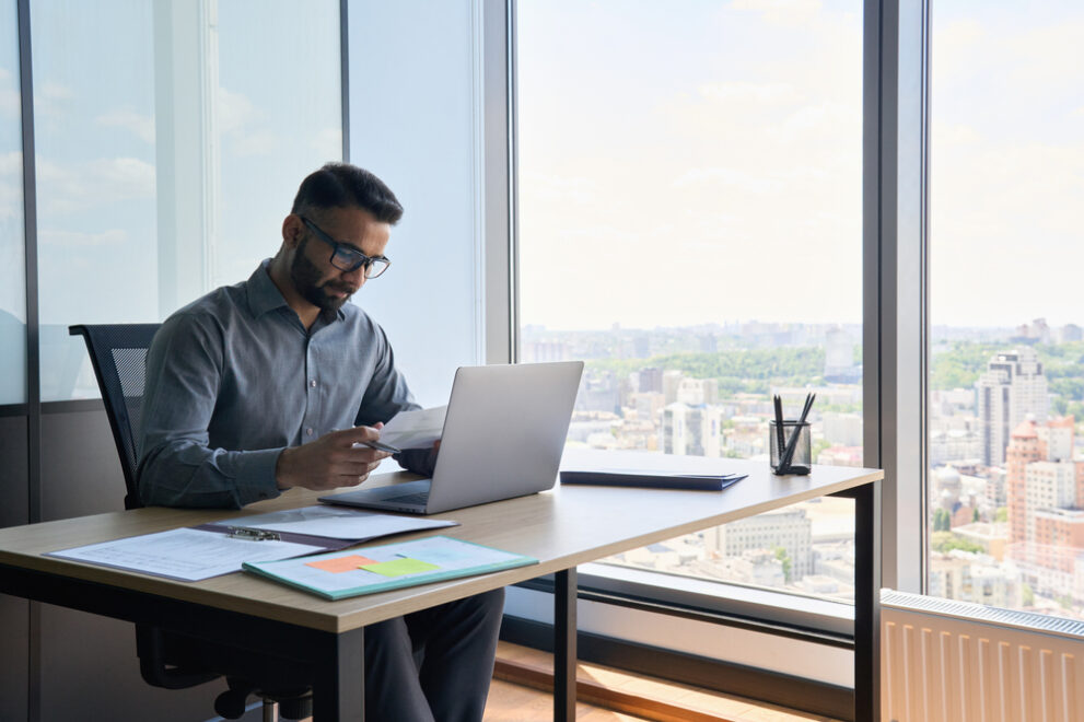 Indian,Latin,Focused,Financier,Sitting,At,Desk,Doing,Paperwork,Working